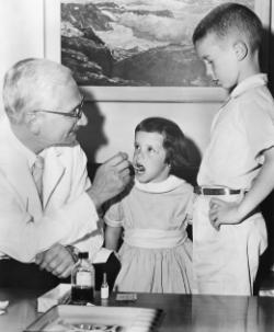 Albert Sabin administering the vaccine that saved millions from polio.